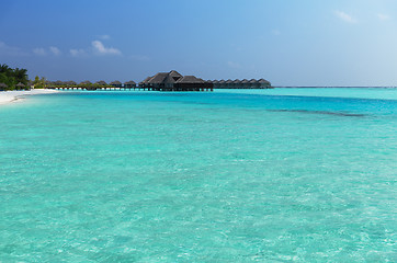 Image showing bungalow huts in sea water on exotic resort beach