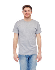 Image showing smiling young man in gray t-shirt and jeans