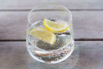 Image showing glass of sparkling water with lemon on table