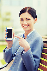 Image showing young smiling businesswoman showing smartphone