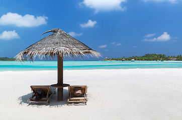 Image showing palapa and sunbeds by sea on maldives beach