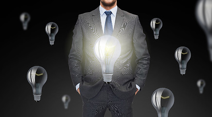 Image showing close up of businessman in suit with ligh bulbs