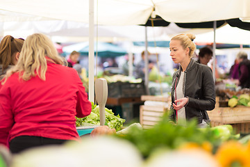 Image showing Woman buying vegetable at local food market. 