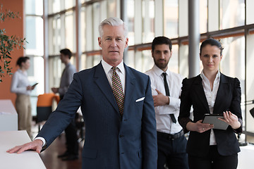 Image showing portrait of senior businessman as leader  with group of people i