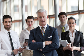 Image showing portrait of senior businessman as leader  with group of people i