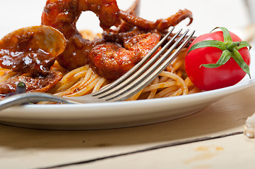 Image showing Italian seafood spaghetti pasta on red tomato sauce 