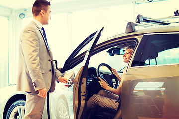 Image showing happy woman with car dealer in auto show or salon