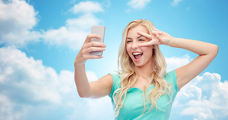 Image showing smiling young woman taking selfie with smartphone