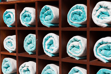 Image showing close up of shelf with rolled bath towels