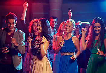 Image showing smiling friends with glasses of champagne in club