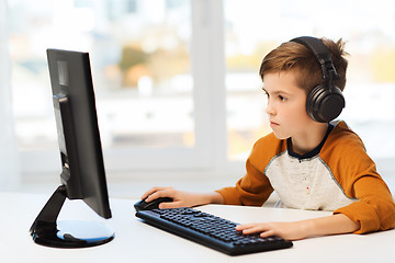 Image showing boy with computer and headphones at home