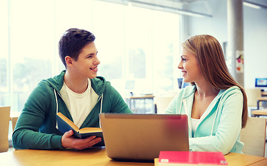 Image showing happy students with laptop and books at library