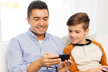 Image showing happy father and son with smartphone at home