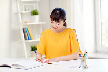 Image showing happy asian young woman student learning at home