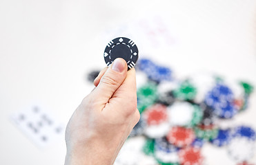 Image showing close up of male hand holding casino chip