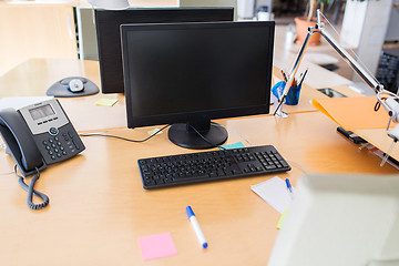 Image showing computers with blank black screen on office table