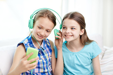 Image showing happy girls with smartphone and headphones