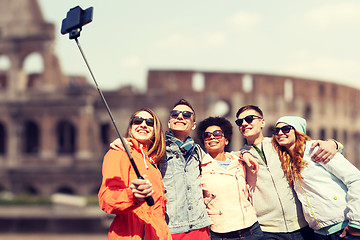 Image showing happy friends with smartphone selfie stick