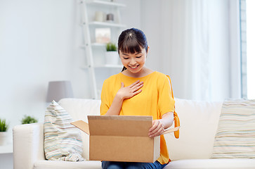 Image showing happy asian young woman with parcel box at home