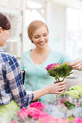 Image showing happy women choosing flowers in greenhouse or shop
