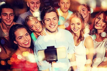 Image showing friends with smartphone taking selfie in club