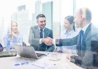 Image showing two businessman shaking hands in office