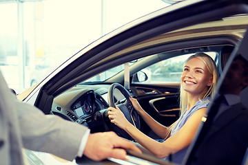 Image showing happy woman with car dealer in auto show or salon