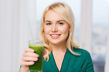 Image showing smiling woman drinking juice or smoothie at home