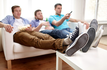 Image showing close up of male friends watching tv at home