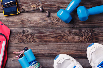 Image showing Sports equipment - sneakers, skipping rope, dumbbells, smartphone and headphones. 