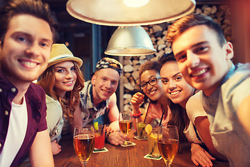 Image showing happy friends with smartphone taking selfie at bar