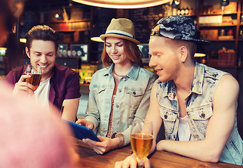 Image showing happy friends with tablet pc and drinks at bar