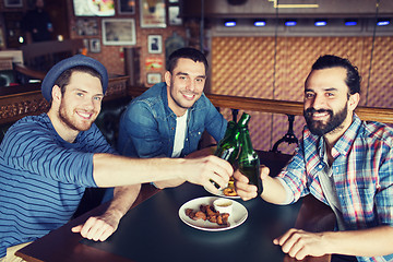 Image showing happy male friends drinking beer at bar or pub