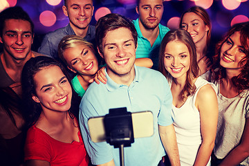 Image showing friends with smartphone taking selfie in club