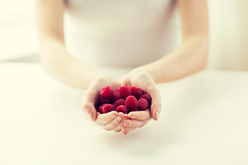 Image showing close up of woman hands holding raspberries