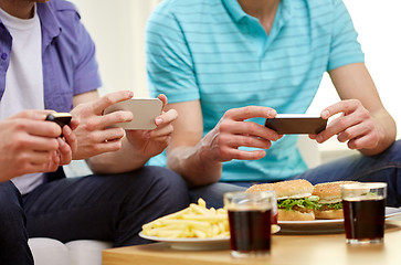 Image showing close up of friends with smartphone picturing food