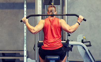 Image showing man flexing muscles on cable machine gym