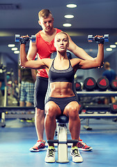 Image showing man and woman with dumbbells in gym