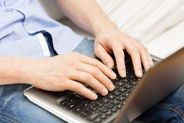 Image showing close up of man typing on laptop computer at home