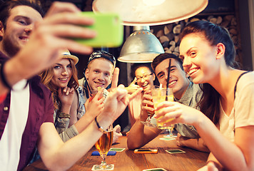 Image showing happy friends with smartphone taking selfie at bar