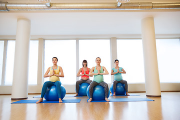 Image showing happy pregnant women exercising on fitball in gym