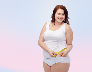 Image showing happy young plus size woman with measuring tape