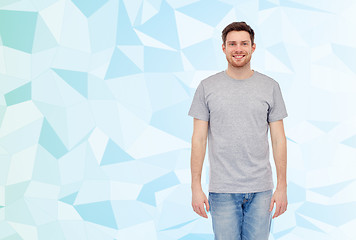 Image showing happy smiling young man in gray t-shirt and jeans