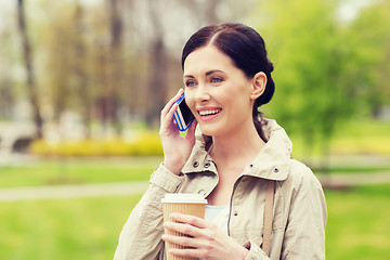 Image showing smiling woman with smartphone and coffee in park