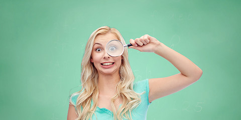 Image showing happy young woman with magnifying glass