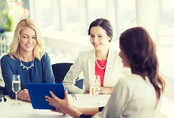 Image showing happy women with tablet pc at restaurant