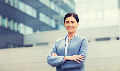 Image showing young smiling businesswoman over office building