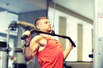 Image showing man flexing muscles on cable machine gym