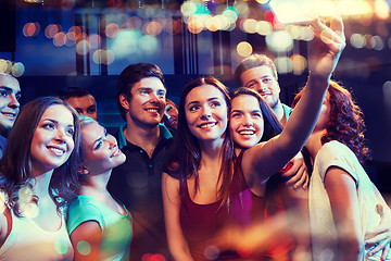 Image showing friends with smartphone taking selfie in club