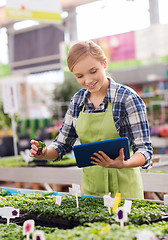 Image showing happy woman with tablet pc in greenhouse